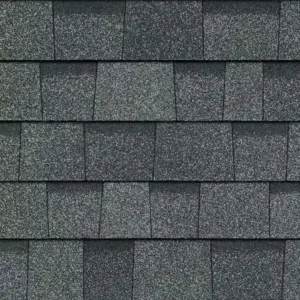 Close-up view of dark gray asphalt roof shingles arranged in a staggered pattern, showcasing the precise work often delivered by professional roofers.