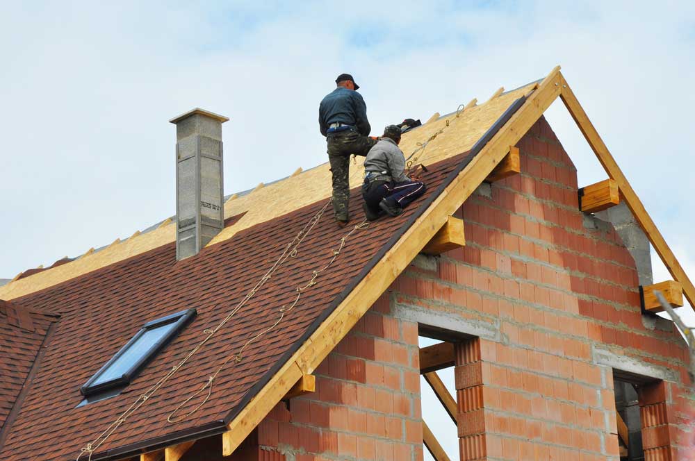 Roof replacement cost Austin TX showing workers on the roof