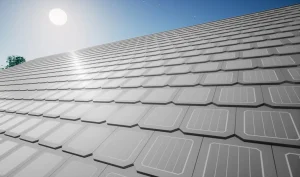 A rooftop covered with solar panel tiles under a bright sun and clear blue sky, showcasing how the best roof shingles can be combined with modern energy solutions.