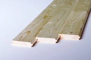 Three wooden tongue-and-groove boards are laid side by side on a white surface, displaying their ends and wood grain patterns—ideal for illustrating a Roof Decking Guide.